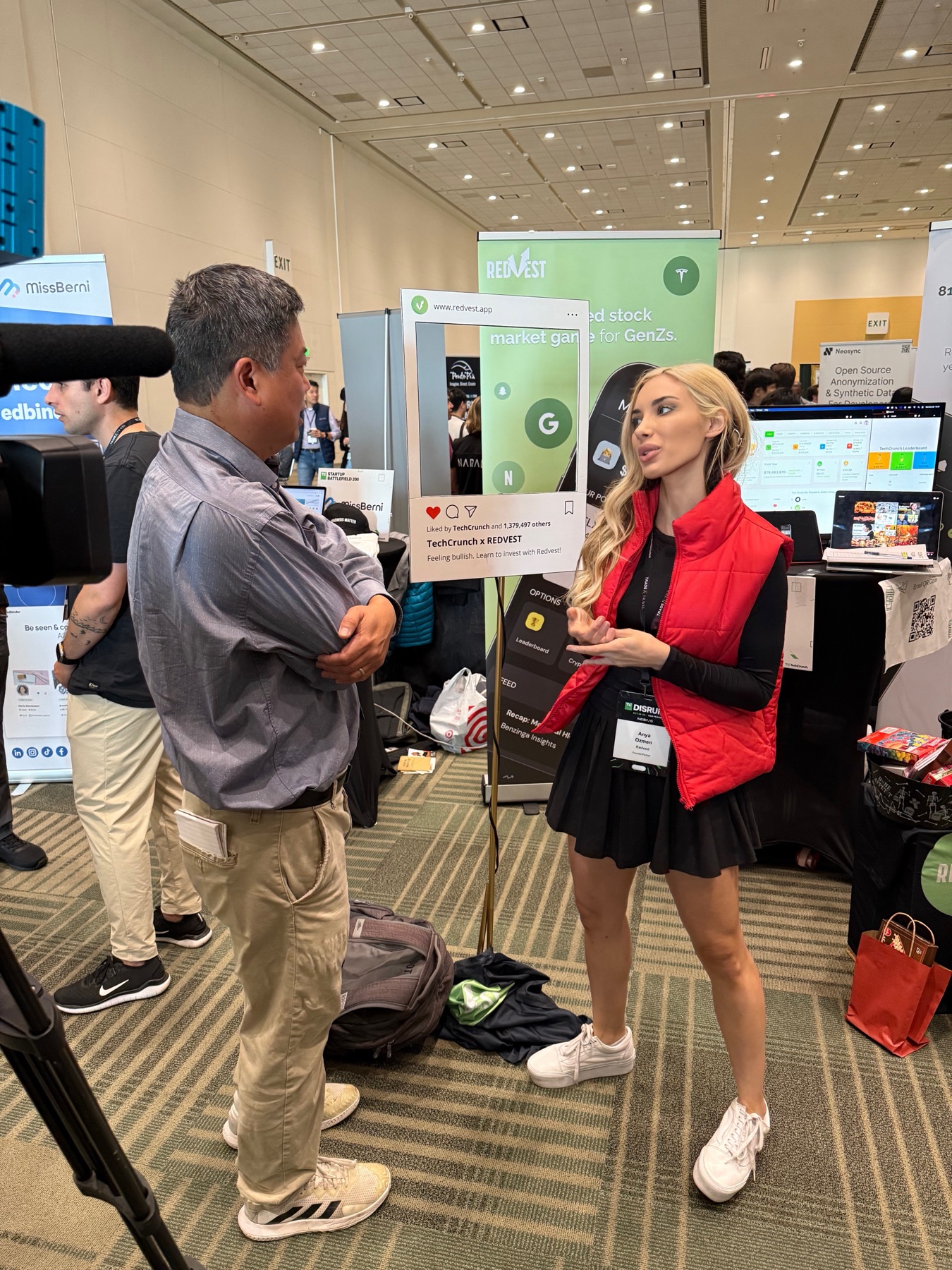 Anya Ozmen discussing Redvest with a reporter beside the stock market game booth