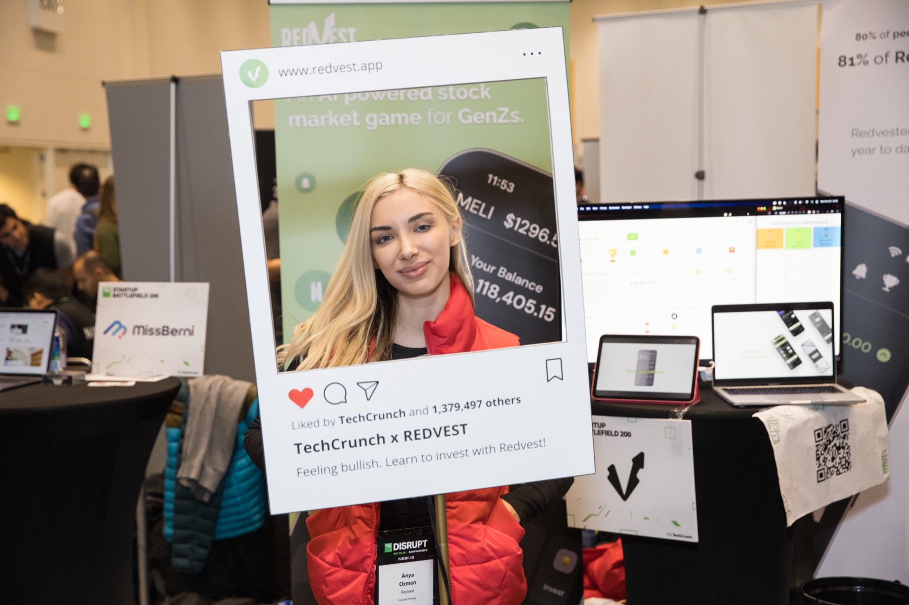 Anya Ozmen holding the TechCrunch x Redvest event frame at the stock market game booth