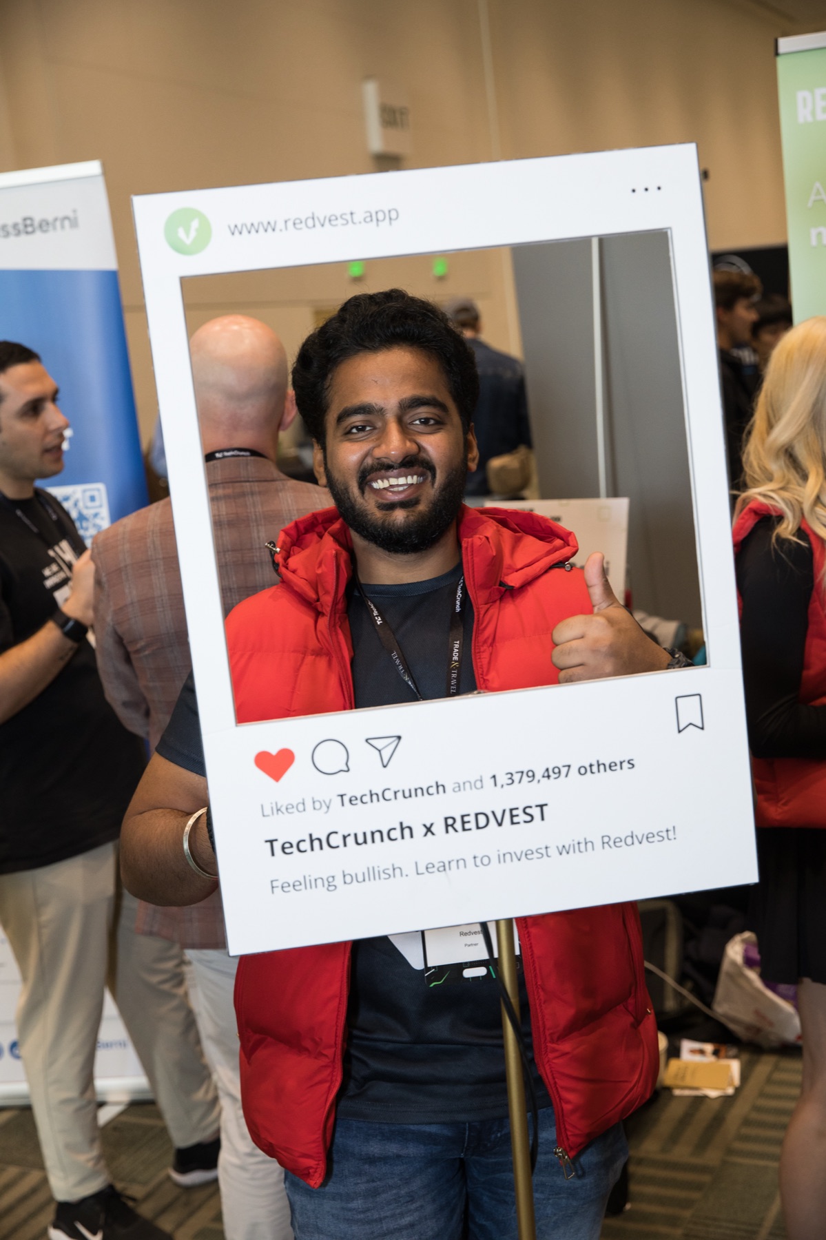 Redvest team member posing with the TechCrunch x Redvest event photo frame