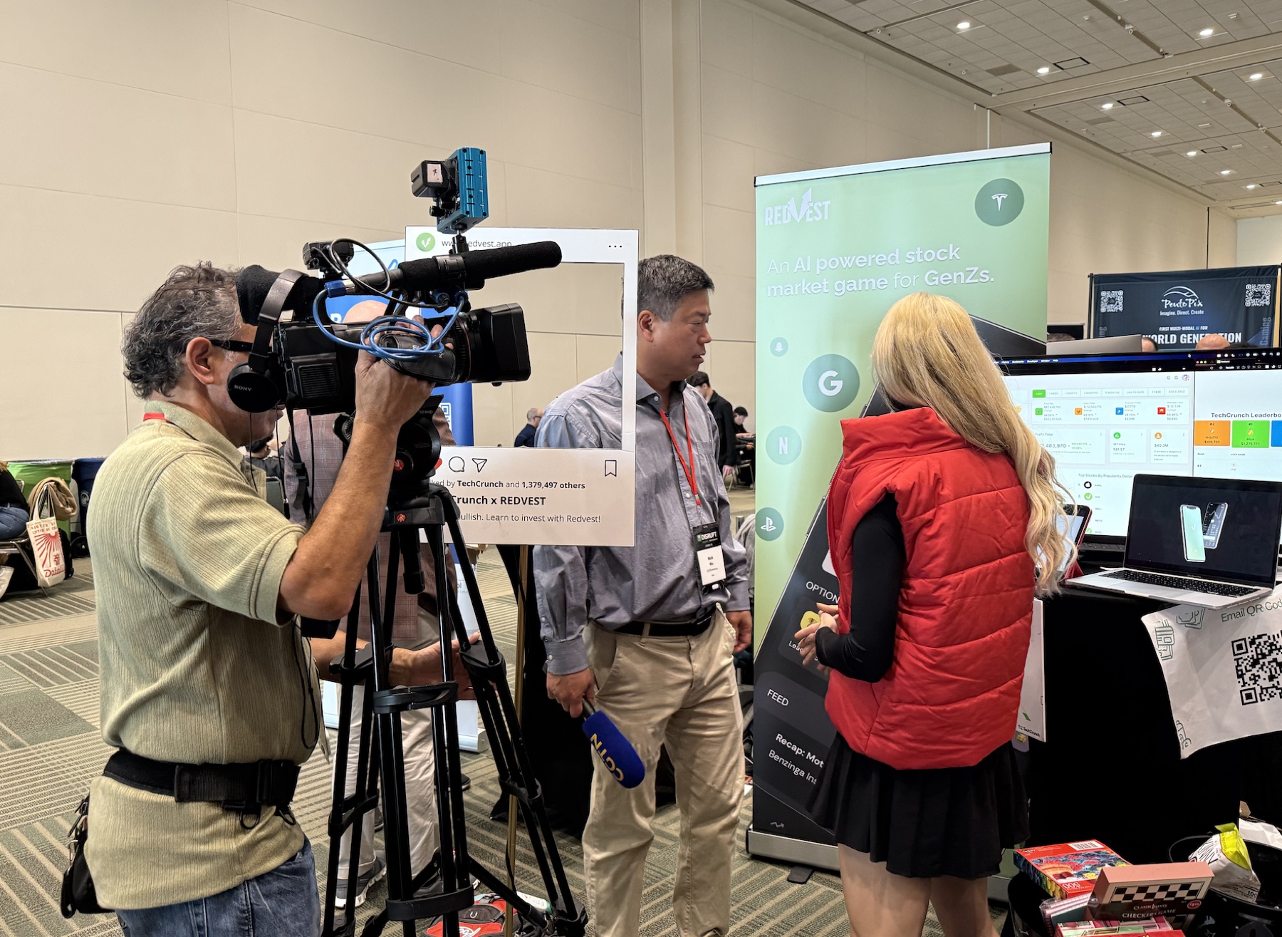Media crew filming the Redvest AI-powered stock market game booth at TechCrunch Disrupt